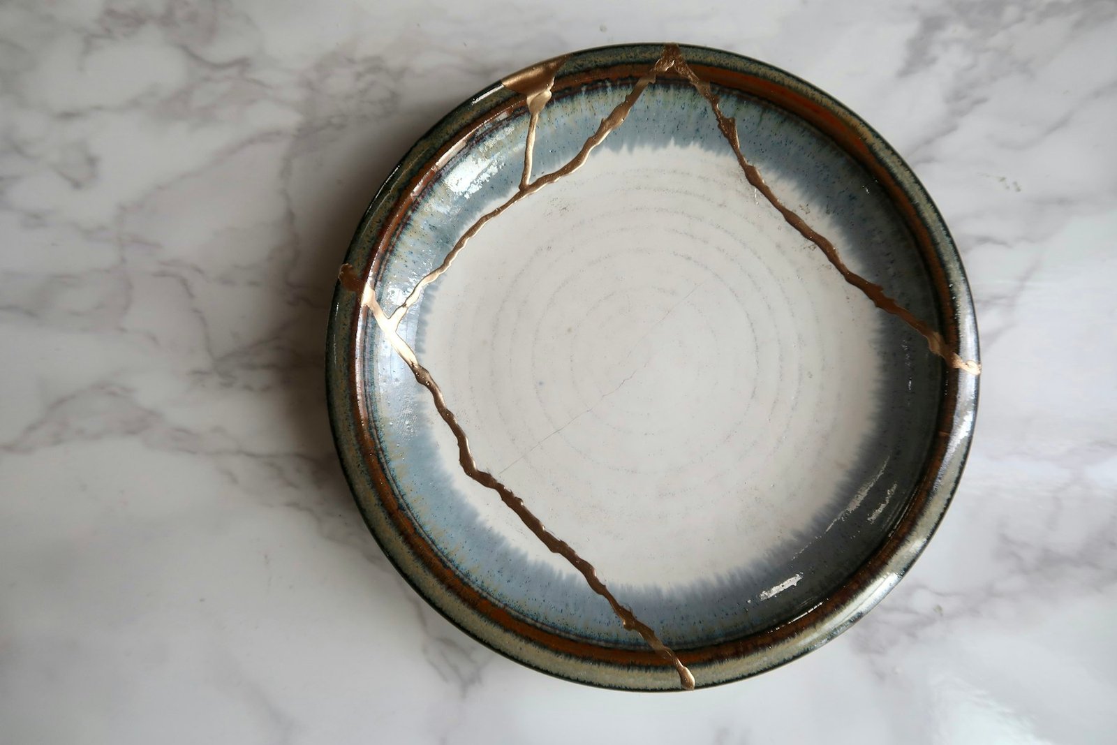 A broken bowl mended with gold seams in the kintsugi tradition